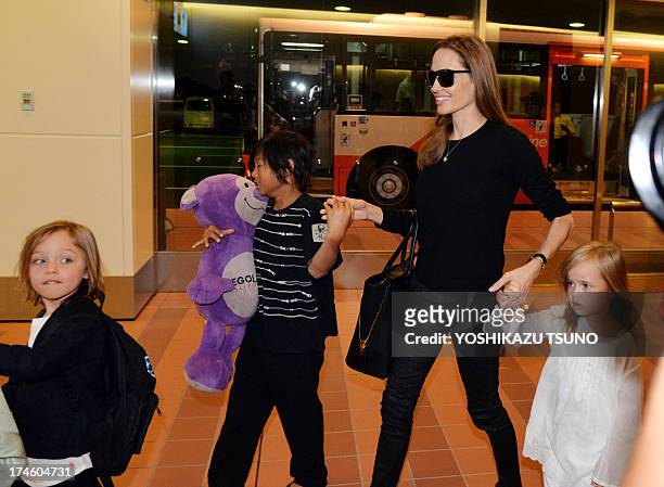 Film star Angelina Jolie smiles as she arrives with her partner Brad Pitt and their children at Haneda International Airport in Tokyo on July 28,...