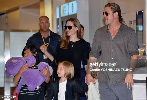 Film stars Brad Pitt and Angelina Jolie , accompanied by their children, arrive at Haneda International Airport in Tokyo on July 28, 2013. Pitt is...