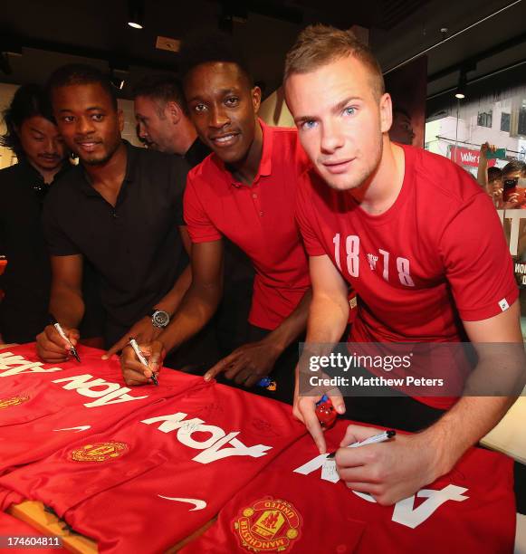 Danny Welbeck, Tom Cleverley and Patrice Evra of Manchester United FC sign United shirts after a Q&A session at the Nike store, Mong Kok as part of...