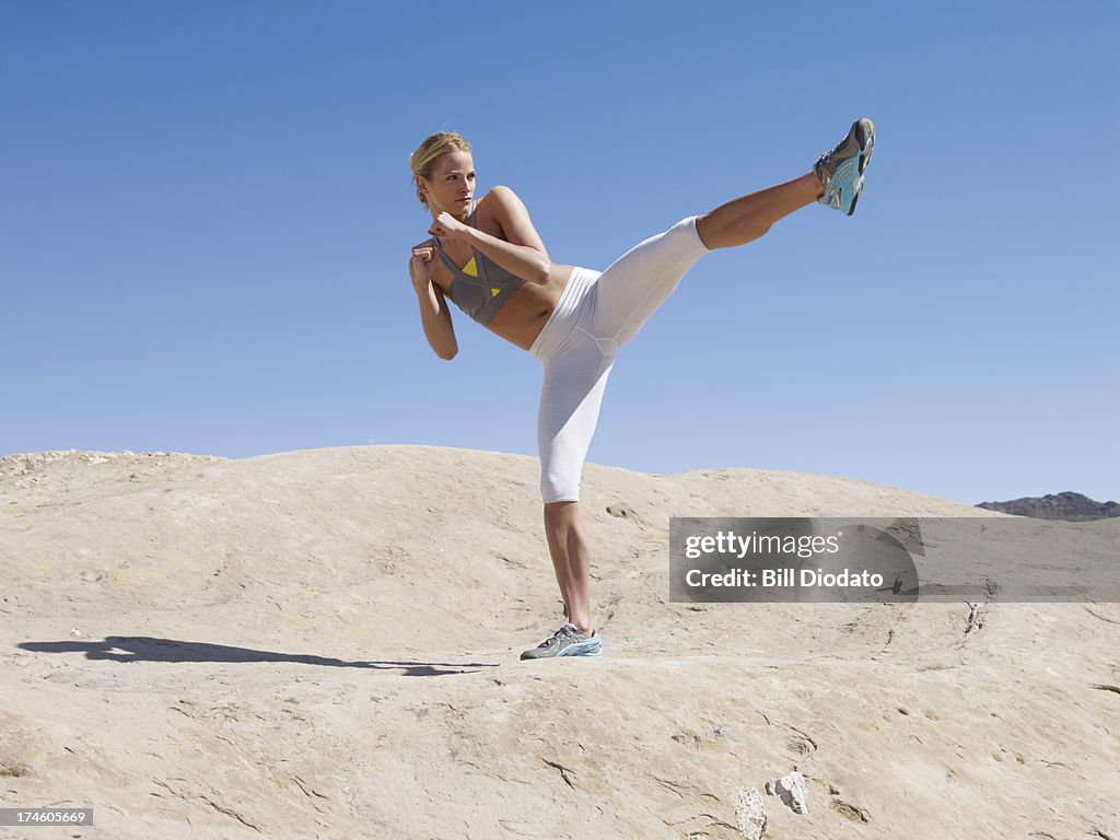 Woman kicking in the desert