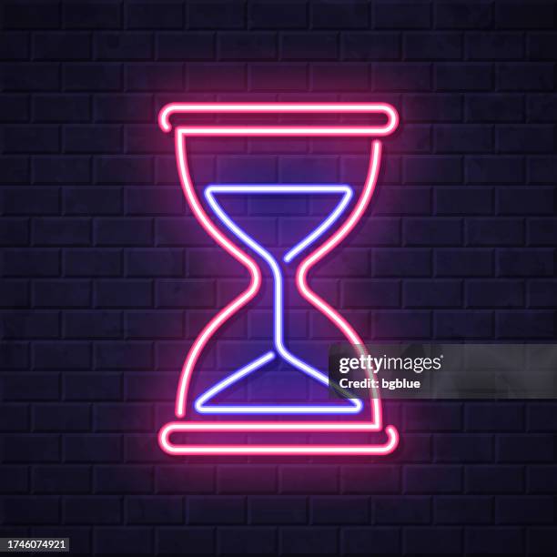 hourglass. glowing neon icon on brick wall background - clock on wall stock illustrations