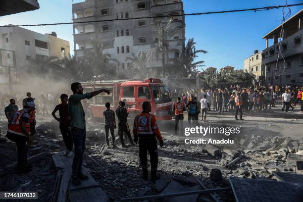 Civil defense teams and civilians conduct search and rescue operations at the rubbles of buildings, destroyed after the Israeli airstrikes, in Rafah,...