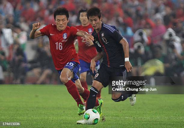 Lee Myung-Joo of South Korea competes for the ball with Yoichiro Kakitani of Japan during the EAFF East Asian Cup match between Korea Republic and...