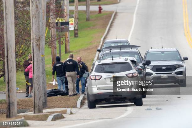 Law enforcement officials investigate outside the site of a mass shooting at Schemengees Bar and Grille on October 26, 2023 in Lewiston, Maine....