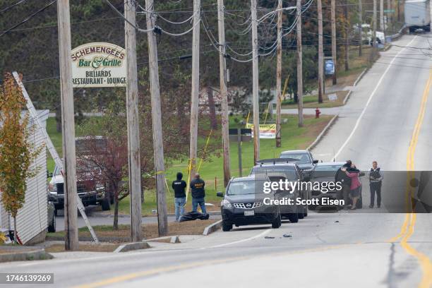 Woman hugs a law enforcement official as they investigate outside the site of a mass shooting at Schemengees Bar and Grille on October 26, 2023 in...