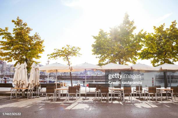 cafe terraces with umbrellas in the city - gijón fotografías e imágenes de stock