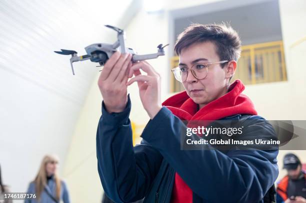Participant looks at a quadcopter while holding it in her hands during UAV pilot training on October 19, 2023 in Lviv, Ukraine. With the beginning of...