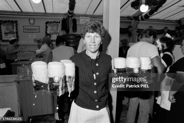 Serveuse avec des chopes de bière pendant l'Oktoberfest à Munich en septembre 1984