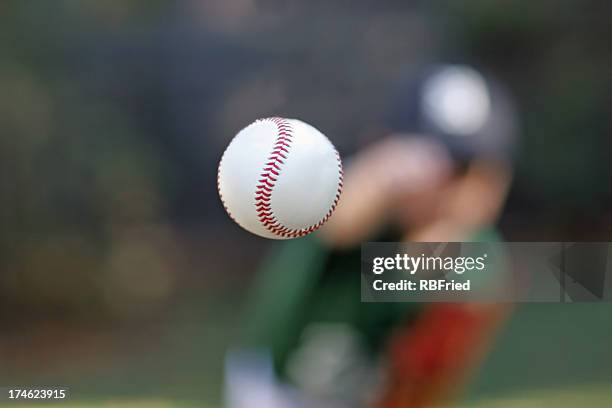 baseball in mid air after being thrown by pitcher - young baseball pitcher stock pictures, royalty-free photos & images