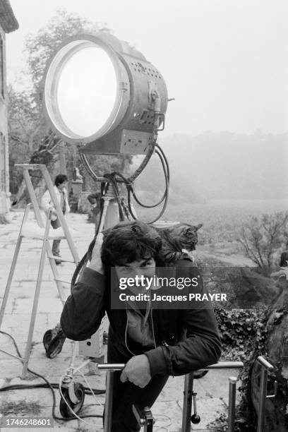 Technicien avec un chat sur l'épaule sur le tournage du film 'Tristesse et Beauté' en octobre 1984