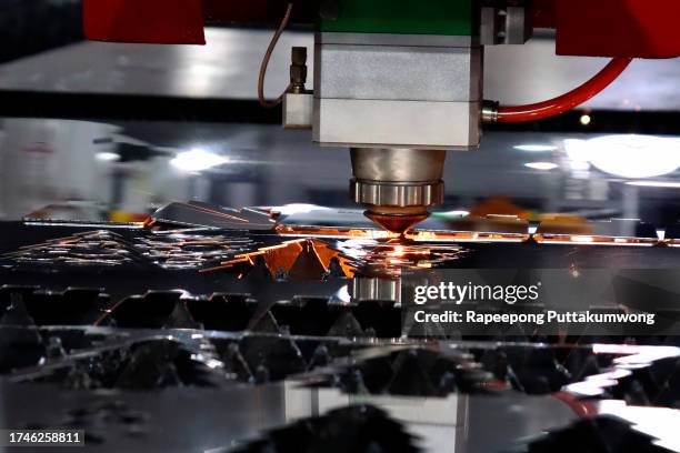 cnc laser cutting of metal with sparks, modern industrial technology. - laser engraving stock pictures, royalty-free photos & images