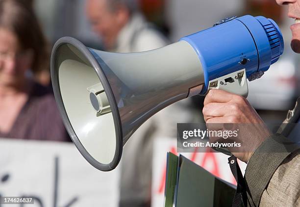 person talking in a blow horn at a demonstration - aston martin: 50 years of bond stockfoto's en -beelden