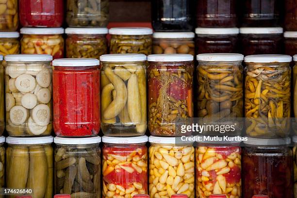 assortment of glass jars filled with pickled vegetables - pickle jar stockfoto's en -beelden