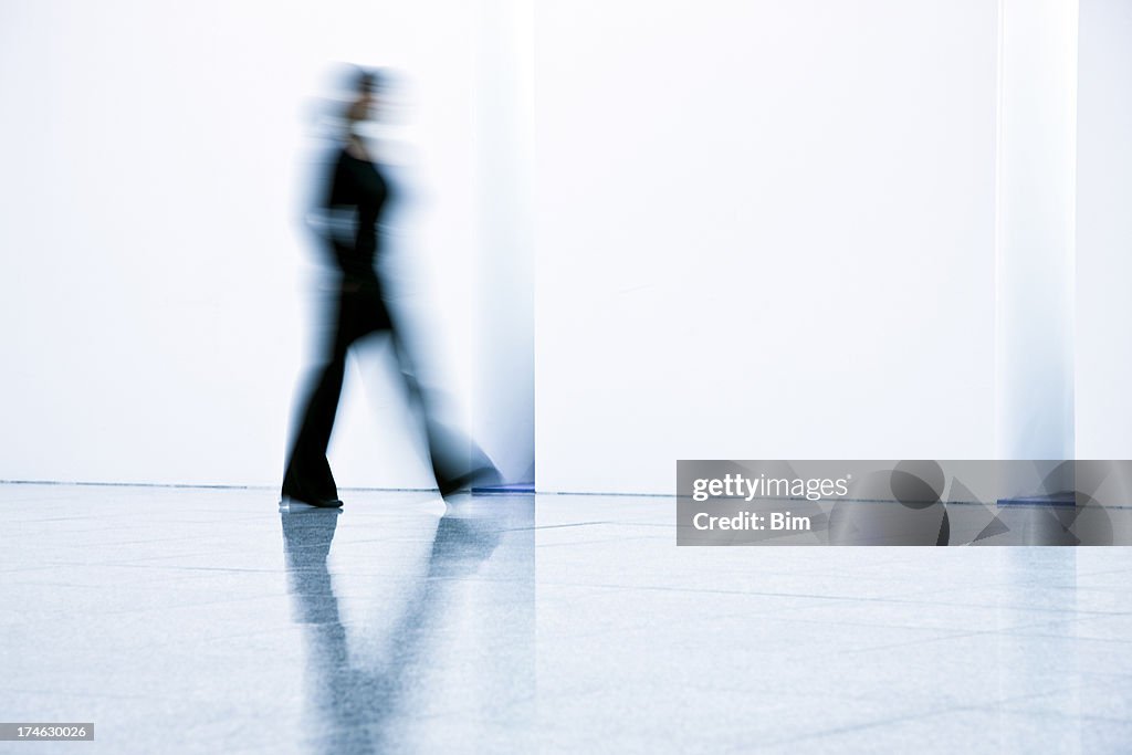 Motion blurred young businesswomen walking