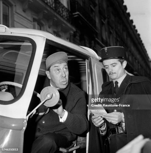 Fernandel contrôlé par un policier au volant d'un camion lors de l'enregistrement de l'émission 'Quand un livreur....... !', le 24 janvier 1961, à...