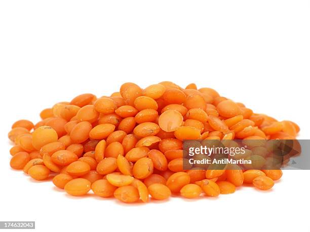 red lentils isolated on white - linze stockfoto's en -beelden