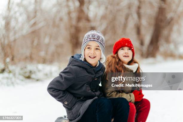 children sitting on the sledge , resting from an adventure on the snow in the winter - family winter sport stock pictures, royalty-free photos & images