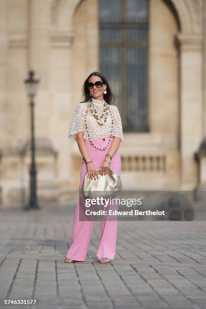 Alba Garavito Torre wears pearl earrings, a long/large pearl necklace, a cream guipure mesh embroidered blouse from Room 717, pink high rise and wide...