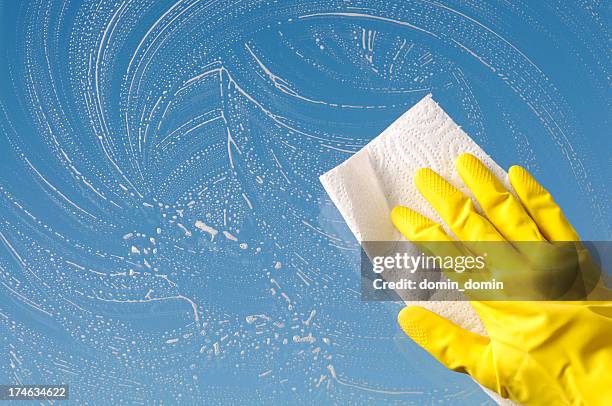 hand in yellow protective glove is cleaning window, sky background - window cleaner stockfoto's en -beelden