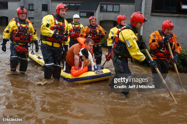 Members of the coastguard rescue a man and a dog from flood waters surrounding the houses on October 20, 2023 in Brechin Scotland. Areas close to the...