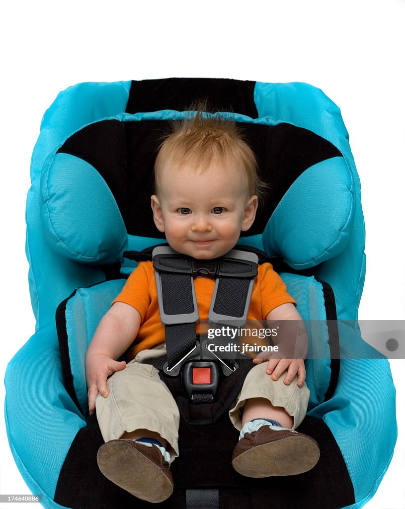 A toddler boy sitting in a blue car seat