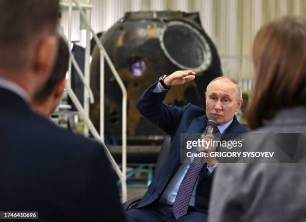 This pool photograph distributed by Russian state owned agency Sputnik shows Russia's President Vladimir Putin talking with young scientists during a...