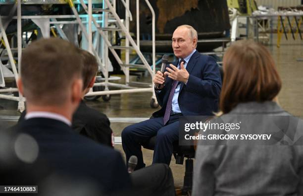 This pool photograph distributed by Russian state owned agency Sputnik shows Russia's President Vladimir Putin talking with young scientists during a...