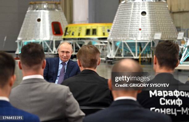 This pool photograph distributed by Russian state owned agency Sputnik shows Russia's President Vladimir Putin talking with young scientists during a...