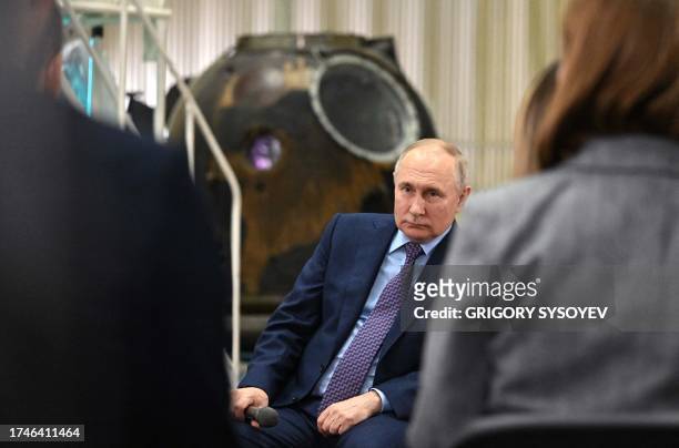 This pool photograph distributed by Russian state owned agency Sputnik shows Russia's President Vladimir Putin talking with young scientists during a...