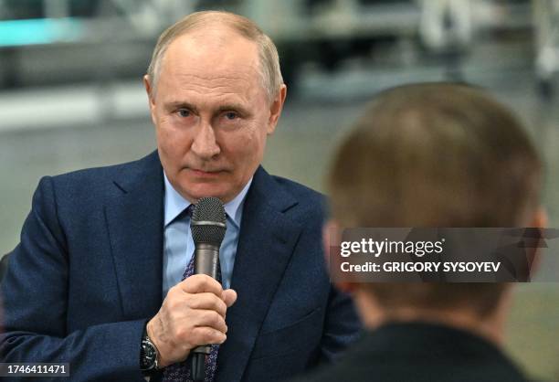 This pool photograph distributed by Russian state owned agency Sputnik shows Russia's President Vladimir Putin talking with young scientists during a...