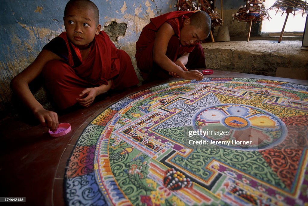 Novice monks at Semtokha Monastery prepare a mandala sand...