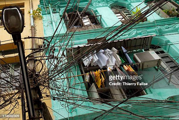 Electric wires and cables dangle in front of an appartment ind downtown Yangon..