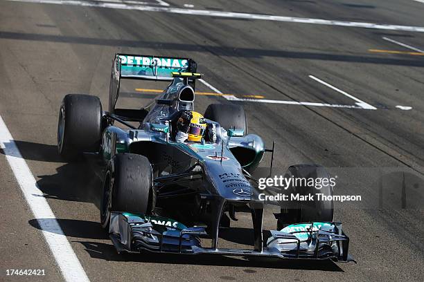 Lewis Hamilton of Great Britain and Mercedes GP celebrates as he crosses the finish line to win the Hungarian Formula One Grand Prix at Hungaroring...