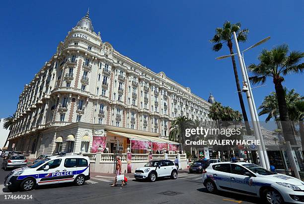 Police cars are parked outside the Carlton Hotel on July 28, 2013 in the French Riviera resort of Cannes, after an armed man held up the jewellery...