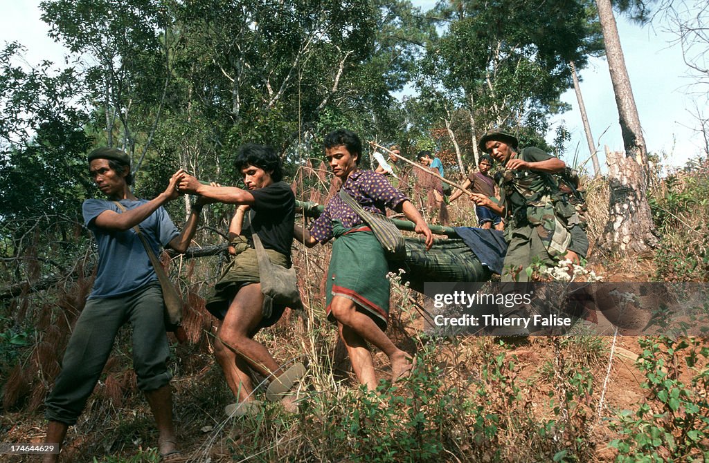 A group of villagers and Free Burma Rangers members carry...