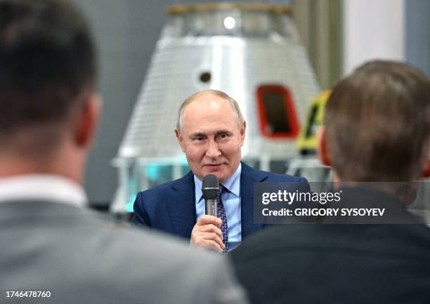 This pool photograph distributed by Russian state owned agency Sputnik shows Russia's President Vladimir Putin talking with young scientists during a...