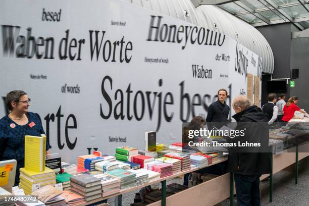 Visitors standing at a stand with books in front of the pavilion of the Guest of Honor country Slovenia at the Frankfurt International Book Fair 2023...
