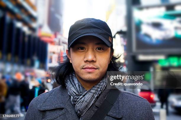 asiatische junge mann porträt in new york city times square - trends asian stock-fotos und bilder