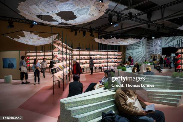 Visitors read books in the pavilion of the Guest of Honor country Slovenia at the Frankfurt International Book Fair 2023 on Sunday, speaks at the...
