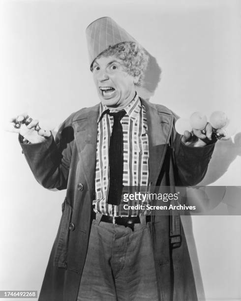 Harpo Marx of the Marx Brothers comedy films wearing lamp shade magician fez hat circa 1940.