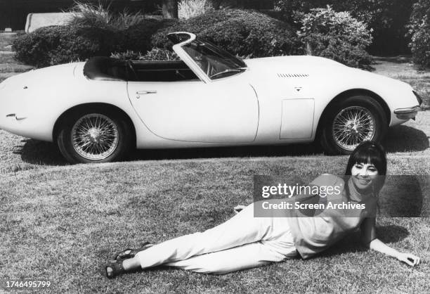 Akiko Wakabayashi poses in front of James Bond's custom Toyota 2000 sports car for the 1967 movie 'You Only Live Twice'.