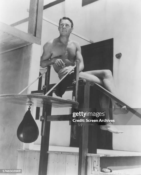 Randolph Scott poses bare-chested on lifeguard tower circa 1940.