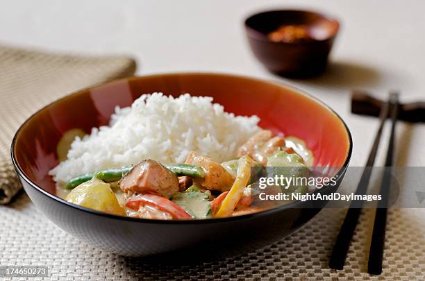 thai curry with fish, vegetables, and rice in asian setting - kokosmelk stockfoto's en -beelden