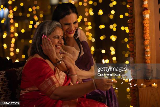 mother and daughter playing with sparklers at home - daughter in law stock pictures, royalty-free photos & images