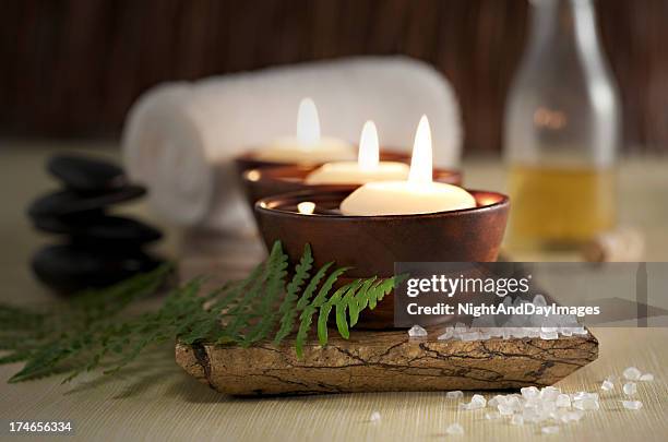 schwimmenden kerzen in eine zen spa, massage steine und öle - ayurveda stock-fotos und bilder