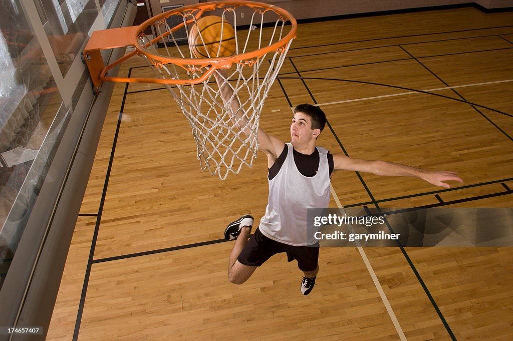 Basketball player jumping in air while trying to score