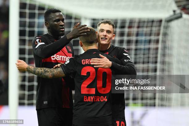 Bayer Leverkusen's Nigerian forward Victor Boniface , Bayer Leverkusen's Spanish defender Alex Grimaldo and Bayer Leverkusen's German midfielder...