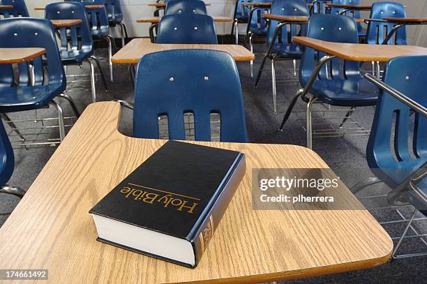 sacra bibbia disteso su un banco di scuola parrocchiale - religion foto e immagini stock