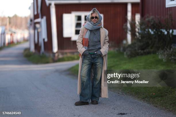 Katarina Krebs seen wearing a black sunglasses, Copenhagen Studios colorful checked wool scarf, grey wool knit pullover, beige corduroy long coat,...