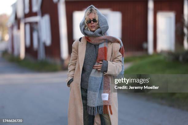 Katarina Krebs seen wearing a black sunglasses, Copenhagen Studios colorful checked wool scarf, grey wool knit pullover, beige corduroy long coat,...